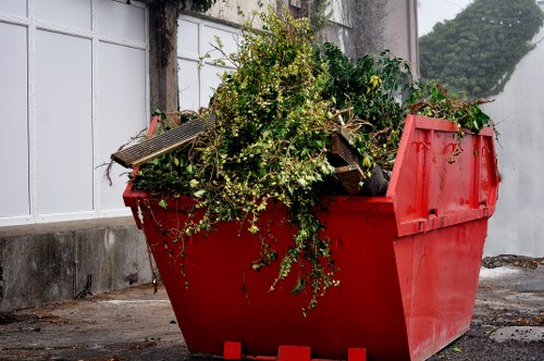 Workers loading waste onto a small van in a city street